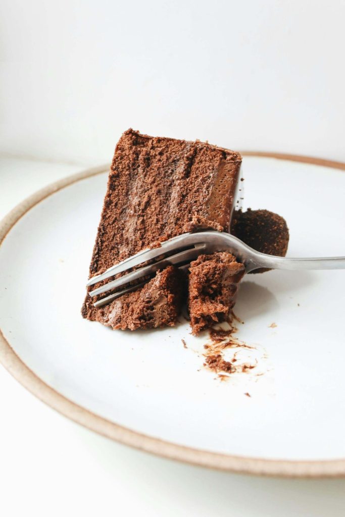 piece of chocolate cake being sliced with a fork