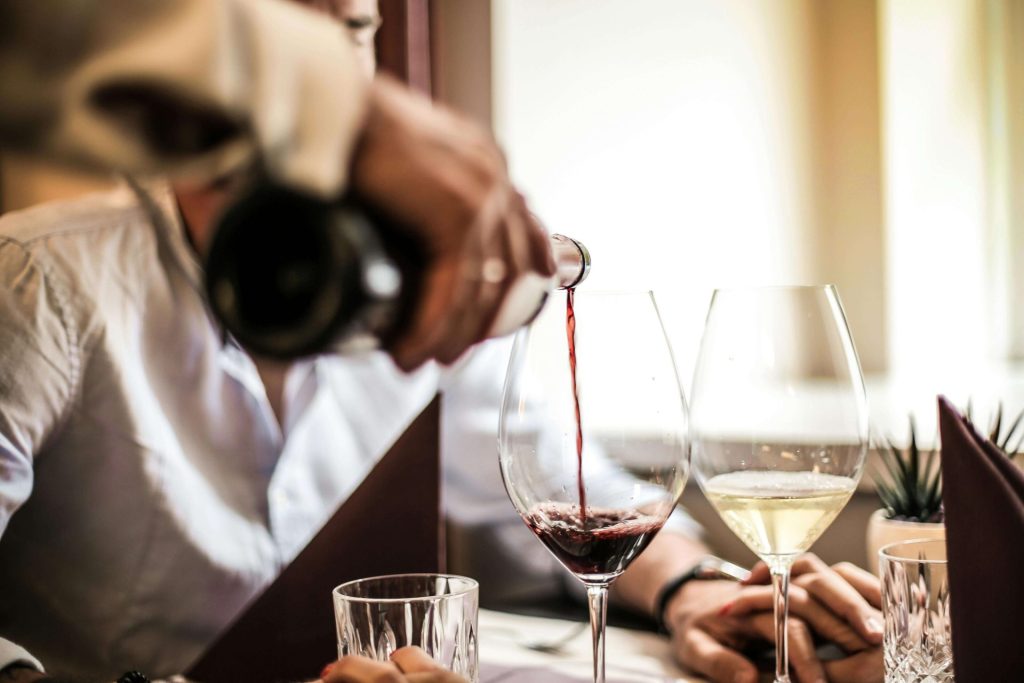 red wine pouring into a wine glass at a nice dinner setting